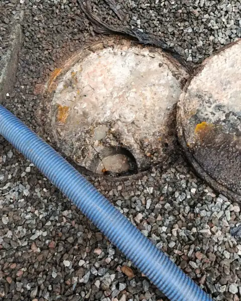 Caixas de gordura redondas com gordura acumulada na superfície, ao lado da mangueira de sucção